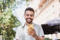 Young handsome student man using smartphone in a city. Cheerful smiling men holding mobile phone Royalty Free Stock Photo