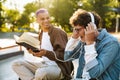 Young handsome stylish boy with book pranking his friend Royalty Free Stock Photo