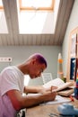 Young handsome stylish focused boy doing homework Royalty Free Stock Photo