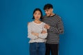 Young handsome stylish guy hugging his offended beautiful asian girlfriend Royalty Free Stock Photo