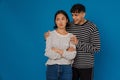 Young handsome stylish guy hugging his offended beautiful asian girlfriend Royalty Free Stock Photo