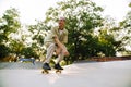 Young handsome stylish short-haired enthusiastic boy riding skateboard Royalty Free Stock Photo