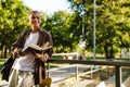 Young handsome stylish short-haired smiling boy holding book looking aside Royalty Free Stock Photo