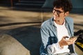 Young handsome stylish smiling curly boy in glasses looking aside Royalty Free Stock Photo