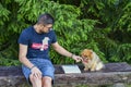 Young handsome smiling man  reading outdoor with a dog Royalty Free Stock Photo