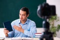 Young handsome teacher recording video for his blog