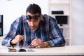 Young handsome technician repairing mobile phone