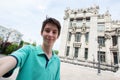 Young handsome teen boy looking at camera and happy smiling takes a selfie with smartphone over Bankova street Royalty Free Stock Photo