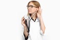 Young handsome trainee doctor in glasses, using a stethoscope to