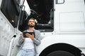 Young handsome truck driver is standing with a tablet near the truck Royalty Free Stock Photo