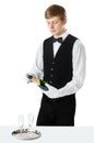 Young handsome waiter opening bottle of champagne