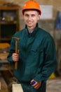 Young and handsome worker man holding a hammer Royalty Free Stock Photo