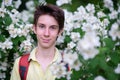 Young handsome 15 years old teen boy wearing yellow t-shirt with backpack looking at camera and happy smiling, summer park outdoor Royalty Free Stock Photo