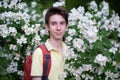 Young handsome 15 years old teen boy wearing yellow t-shirt with backpack looking at camera and happy smiling, summer park outdoor Royalty Free Stock Photo