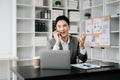 Young handsomel man using laptop and tablet while sitting at her working place. Concentrated at work. in office Royalty Free Stock Photo