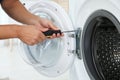 Young handyman fixing washing machine, closeup Royalty Free Stock Photo