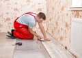 Young handyman installing wooden floor