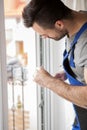 Young handyman repair window