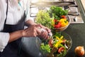 Young happiness Woman Cooking vegetables salad in the kitchen, H Royalty Free Stock Photo