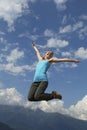 Young happiness woman is jumping against blue sky. summer sunny day Royalty Free Stock Photo