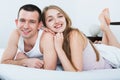 Young happy adults lying in family bed