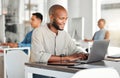 Young happy african american businessman working on a laptop in an office at work. Content male businessperson typing an Royalty Free Stock Photo