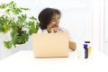 Young happy African-American female doctor sitting in front of laptop enjoying work in modern clinic Royalty Free Stock Photo