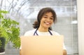 Young happy African-American female doctor sitting at workplace looking to the camera Royalty Free Stock Photo