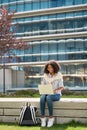 Young happy African American girl student using laptop studying in park. Royalty Free Stock Photo