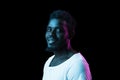 Young happy African-American man isolated on dark background in neon light Royalty Free Stock Photo
