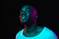 Young happy African-American man isolated on dark background in neon light Royalty Free Stock Photo