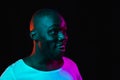 Young happy African-American man isolated on dark background in neon light Royalty Free Stock Photo