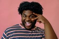 young happy african american man posing in the studio over pink background