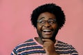 young happy african american man posing in the studio over pink background