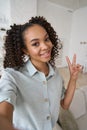 Young happy African American teen girl holding phone looking at mobile camera. Royalty Free Stock Photo