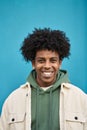 Young happy African American teen guy standing at blue wall. Vertical portrait Royalty Free Stock Photo