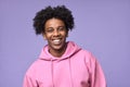 Young happy African American teen guy wearing pink hoodie isolated on purple. Royalty Free Stock Photo