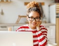 Young happy African-American woman freelancer smiling at camera, enjoying remote work at home office Royalty Free Stock Photo