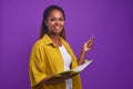 Young happy African American woman holding open folder for documents and pen Royalty Free Stock Photo