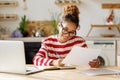 Young happy african american woman remote worker analyzing financial report while working remotely at home Royalty Free Stock Photo