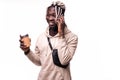 Young happy African man smiling while talking on mobile phone and holding coffee cup isolated against white background Royalty Free Stock Photo