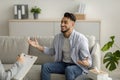 Young happy arab guy talking to his psychologist, receiving professional help, sitting on sofa at mental health clinic Royalty Free Stock Photo