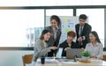 Young happy Asian business man, woman work together, celebrate success in start up office. Creative team brainstorm meeting, Royalty Free Stock Photo