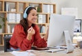 Young happy asian businesswoman wearing headphones while working on a computer in an office. One female only listening