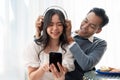 Young happy Asian couple enjoying listening to music together, spending time together at home Royalty Free Stock Photo
