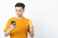 Young happy Asian man reading message from smartphone and holding credit card with copyspace on white background. Royalty Free Stock Photo