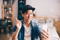 Young happy Asian man talking video call via smartphone wearing headphones at home. Royalty Free Stock Photo