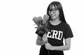 Young happy Asian nerd teenage girl smiling and holding red roses ready for Valentine`s day Royalty Free Stock Photo