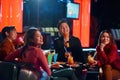 Young happy asian people having fun while singing karaoke on night party at bar. Royalty Free Stock Photo