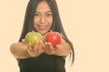 Young happy Asian teenage girl smiling while giving green and red apple Royalty Free Stock Photo